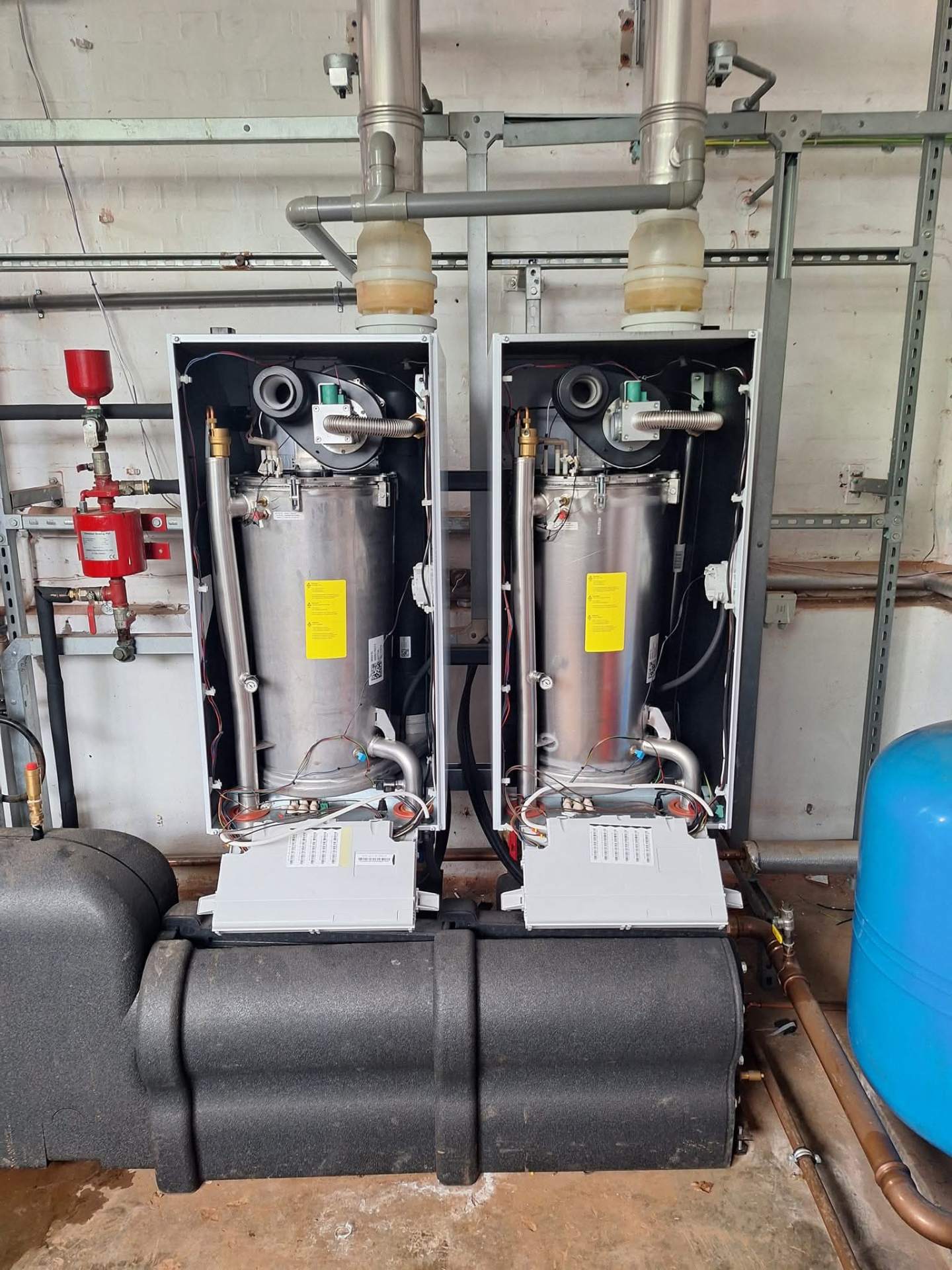 Twin commercial boilers and low-loss header serviced in a commercial plant room
