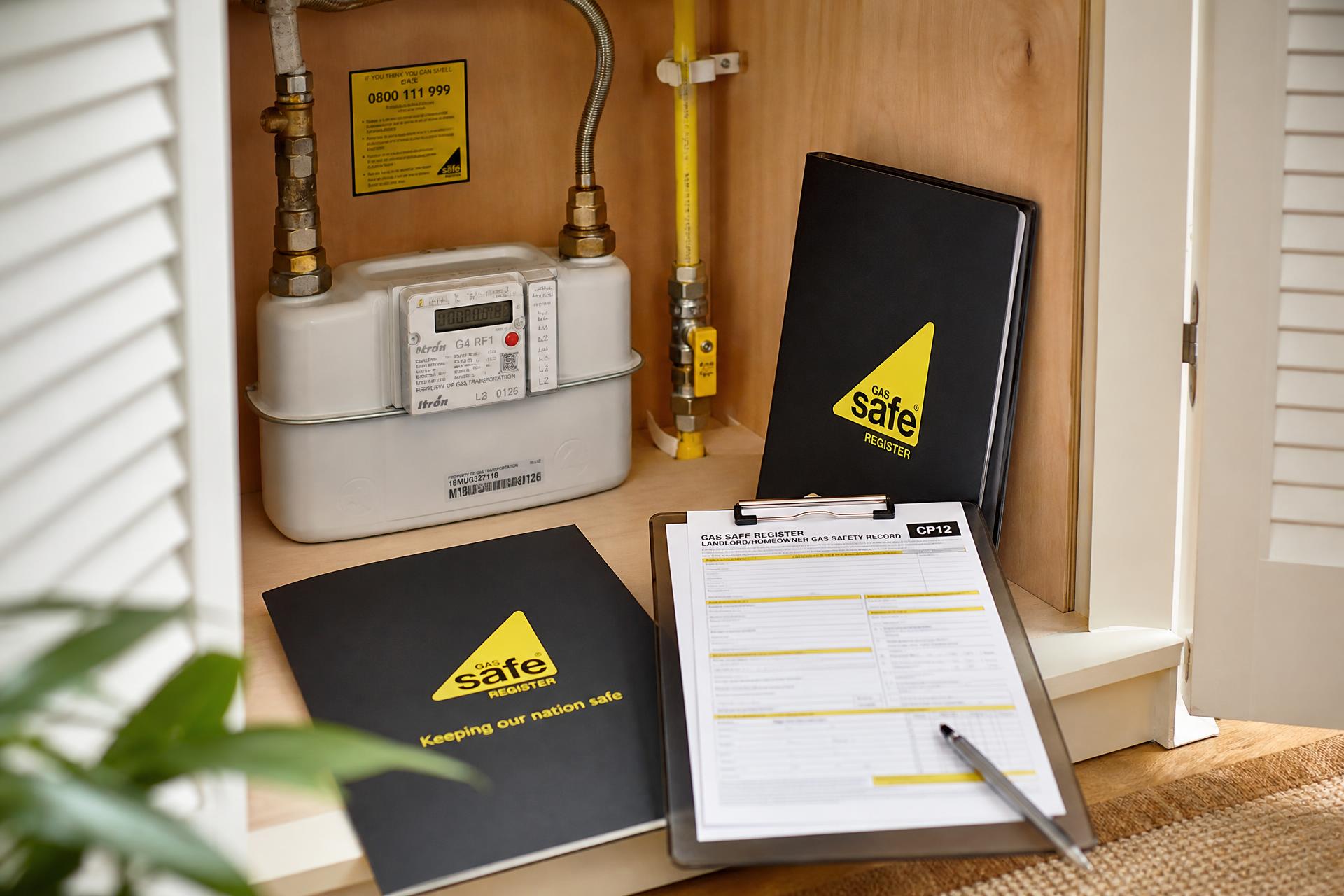 Domestic gas meter with Gas Safe Register CP12 gas safety certificate paperwork ready for inspection